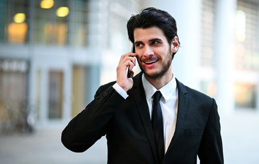 Young manager on the phone outdoor in an urban setting