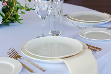 A white plate lies on the table with a white tablecloth on a solemn day