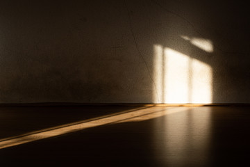 The sunlight shines through the window on space of blank floor and grunge dark wall, depress scene concept