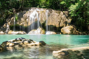 Fototapeta na wymiar Clear stream that flows through the rocks. Falling into the Emerald Pool, Erawan Kanchanaburi, Thailand.