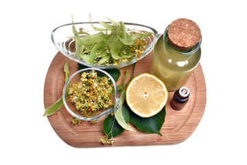 Fresh healthy linden flowers, lemon and tea with essential oil on a white background