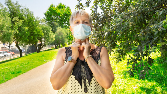 Mature Aged Woman In Protective Mask In Urban Garden. Health Care And Protection Concept. Social Distancing. After Lock Down Quarantine Time.