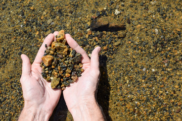 Natural sea stones in the hands. Man is holding stones.