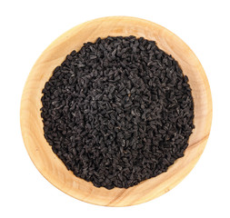 Nigella sativa or Black cumin in wooden bowl isolated on white background. Top view. Flat lay.