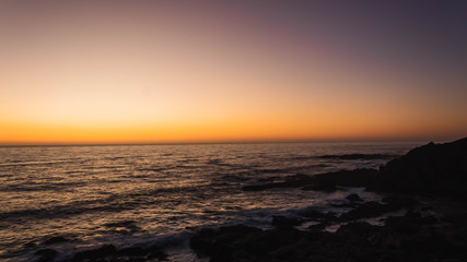 Hermoso atardecer en el borde costero de las playas de Punta Tralca en Chile.Puesta de sol en el océano.Cielo despejado con hermosos tonos anaranjados y violeta.