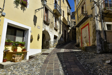 Fototapeta na wymiar A narrow street among the old houses of Altomonte, a rural village in the Calabria region.