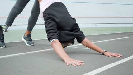 Athlete with prosthetic leg practicing yoga on track. Lady training outdoors