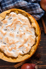 Pear pie with cream, homemade pastries on the wooden table, with spices. Copy space.