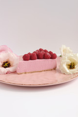 Raspberry cheesecake with berries and fresh flowers on pink plate food photo, sweet cake food photo art, kitchen, menu and restaurant photoshoot