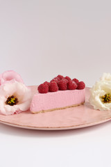 Raspberry cheesecake with berries and fresh flowers on pink plate food photo, sweet cake food photo art, kitchen, menu and restaurant photoshoot