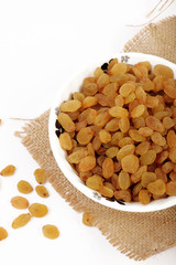 Bowl with dried golden raisins isolated on white. Dried Grapes.