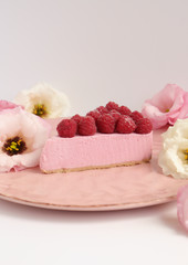 Obraz na płótnie Canvas Raspberry cheesecake with berries and fresh flowers on pink plate food photo, sweet cake food photo art, kitchen, menu and restaurant photoshoot