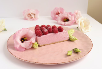 Raspberry cheesecake with berries and fresh flowers on pink plate food photo, sweet cake food photo art, kitchen, menu and restaurant photoshoot