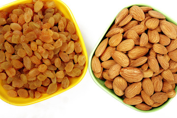 Bowl with dried golden raisins isolated on white. Dried Grapes.