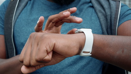 Athlete hands using smartwatch outdoors. Jogger checking results on smart watch