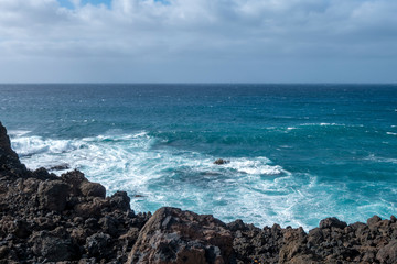 Fototapeta na wymiar Blaues Meer und Vulkangestein