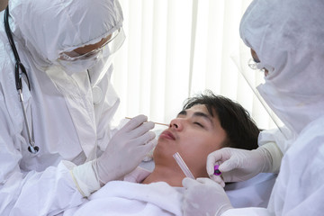 male nurse and doctor wearing ppe suit and facemask perform Coronavirus COVID-19 PCR test. patient nasal NP and oral OP swab sample specimen collection process, viral rt-PCR DNA diagnostic procedure.