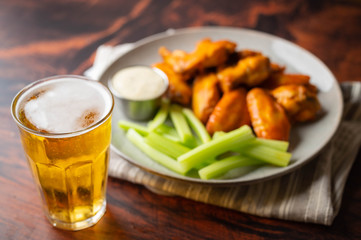 buffalo wings with celery,  ranch dressing and beer