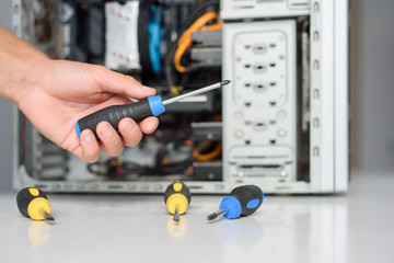 A man fixing a computer with screwdriver