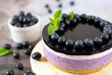 Round blueberry vegan cheesecake with berries and mint leaves on top