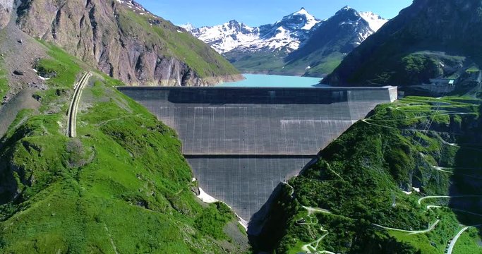 Dixence Dam in the middle of a Mountain with a beautiful blue lake. Renewable Energy and Electric Power technology scene. Beautiful landscape in Aerial view with a drone 4k