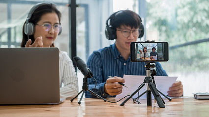 Young business people recording a podcast in a studio
