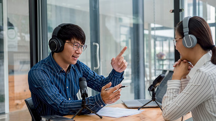 Young business people recording a podcast in a studio