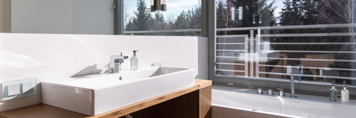 Panorama of stylish bathroom with window