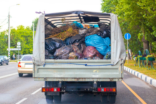 Truck With Garbage Bags In The Back. Cleaning And Transportation Of Household Waste.