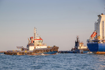 Tug at the seaport. Towing operation in the port
