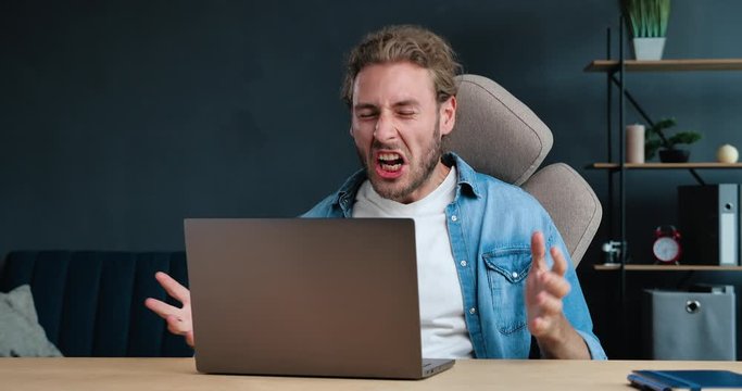 Stressed overworked Businessman feels frustrated by data loss, using Laptop at Home Office. Shocked male user looks at Computer screen reads bad news, has Unexpected online Website problem.