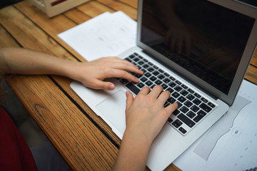 Fototapeta premium Unrecognizable woman with laptop sitting indoors in office, working.