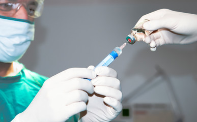 Senior anesthesiologist or doctor hold syringe prepare for injection in operating theatre, Epidural analgesia, Epidural nerve block, spinal block, Pain relief.Senior doctor with experience. - obrazy, fototapety, plakaty