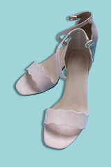nude beige sandals on a blue background. powder palette, bodily colors. Popular fashion shade. isolated