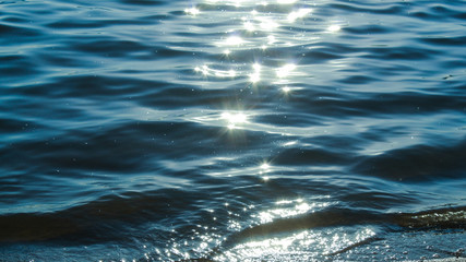 Sun glare in waves of sea water on a tropical beach in summer in nature close-up. Beautiful texture...
