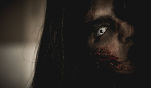 Woman in ghost or zombie on halloween festival at dark place, looking and screming in front of wall. Horror or halloween festival concept.