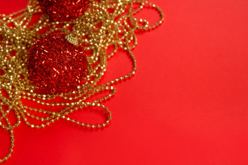 Beautiful Christmas and New Year composition with golden decorations and red christmas balls on bright red background. Festive backdrop with copyspace for your project or greeting card
