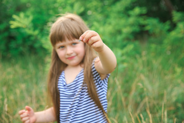 Little girl holding a butterfly in her hand, sharpness on her hand