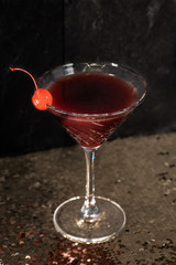 Cocktail drink on a old stone board. Alcoholic beverage with tropical fruits red pepper herb and ice. cocktail in glass on black background. Copyspace. Close up of glass of cocktail 