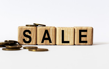 wooden cubes and SALE, coins, the concept of taxation, increase taxes and fees