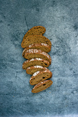 Loaf of sliced sourdough bread on a dark background, top view, food top down. Handmade Whole Grain Dark Bread