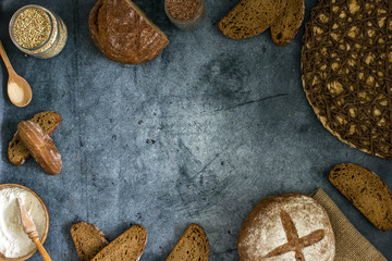 Different homemade breads on a dark table background frame