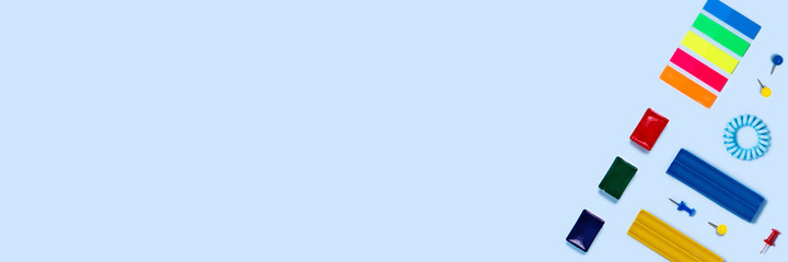 Back to school web banner with color watercolors, plasticine, notepad on blue background.