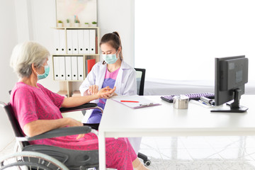 Obraz na płótnie Canvas asian doctor use hand screening vital sign of old asian patient, doctor treatment patient in hospital, elderly health check up, they wear surgical mask
