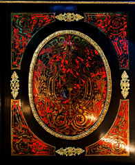 Black and red paint ornamented panel with metal decorations