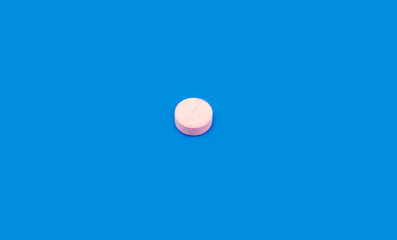 Pink pill on blue background. Bright pill on indigo background. Blue seamless pattern and pink pill.