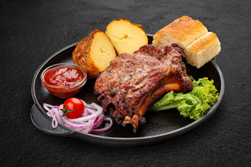 Grilled veal steak with baked potatoes, matnakash and red sauce. Served in a cast iron pan