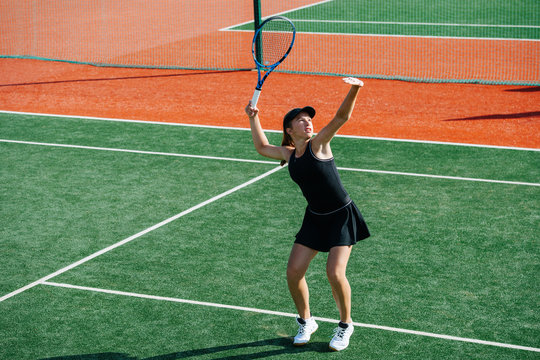 Looking Up Girl Playing Tennis On A New Court, Ready To Return Overhead Ball