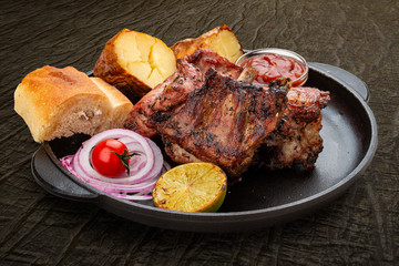 Grilled veal steak with baked potatoes, matnakash and red sauce. Served in a cast iron pan