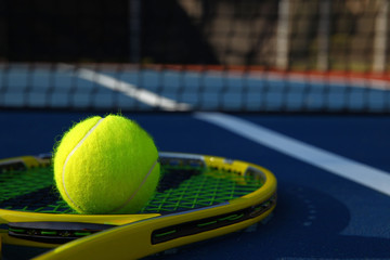 Tennis ball on racket sitting by the net